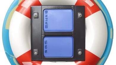 A circular pool float with red and white stripes surrounds a black mount holding two blue, rectangular buttons. The float appears to have a teal border, and the buttons are labeled with text and symbols, possibly for functions like KhanPC or Video Recovery.